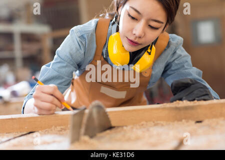 Ritratto di giovane donna falegname concentrare sul suo lavoro Foto Stock