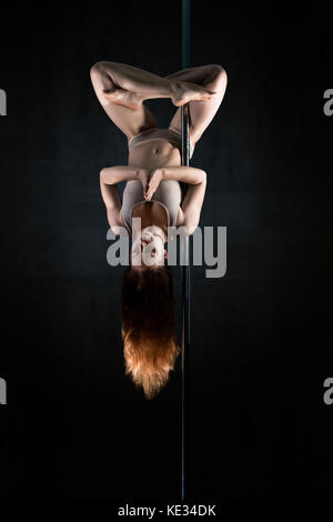 Giovane donna in meditazione lotus posizione capovolta sul polo Foto Stock