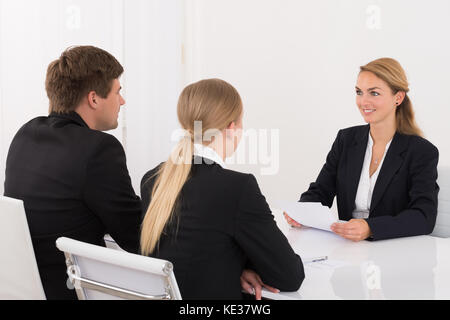 Manager intervistando il giovane maschio e femmina ricorrente in office Foto Stock