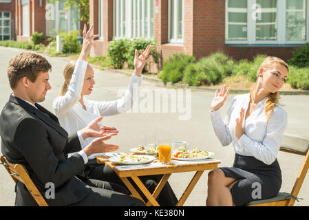 Un gruppo di tre giovani imprenditori aventi argomento in ristorante Foto Stock