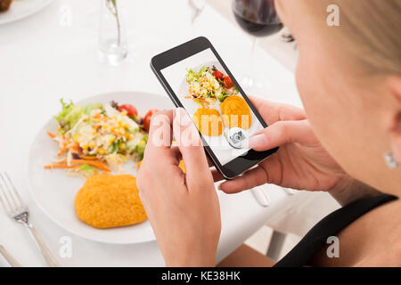 Close-up di donna sta immagine di alimenti con il telefono cellulare Foto Stock