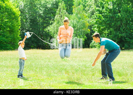 Famiglia giocando con il Salto con la corda nel Parco Foto Stock