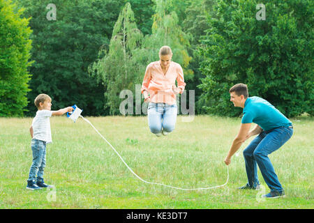 Famiglia giocando con il Salto con la corda nel Parco Foto Stock