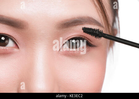 Occhio compongono applicare. Spazzolino per mascara. ritratto di bella donna asiatica con fresco perfetto la pelle del viso. Foto Stock