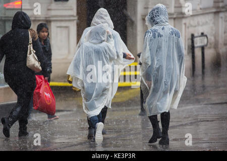 Windsor, Regno Unito. Xviii oct, 2017. i turisti a scomparsa che indossano ponchos lasciare il castello di Windsor durante un improvviso acquazzone. il ramo di ritorno della cerimonia del cambio della guardia dal 1° battaglione delle guardie coldstream è stata annullata in seguito molto heavy rain. Credito: mark kerrison/alamy live news Foto Stock