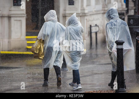 Windsor, Regno Unito. Xviii oct, 2017. i turisti a scomparsa che indossano ponchos lasciare il castello di Windsor durante un improvviso acquazzone. il ramo di ritorno della cerimonia del cambio della guardia dal 1° battaglione delle guardie coldstream è stata annullata in seguito molto heavy rain. Credito: mark kerrison/alamy live news Foto Stock