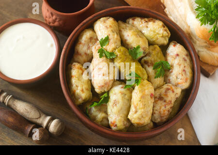 Involtini di cavolo servito con panna acida, il pane e il vino tradizionale o moldavo rumeno piatto sarmale, tradizionale russo o ucraino golubtsy. appare Select Foto Stock