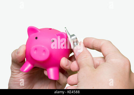 Man mano uno stetoscopio rosa salvadanaio isolati su sfondo bianco. health care costo. finanziaria condizione stato self assessment concetto. sist. finanziaria Foto Stock