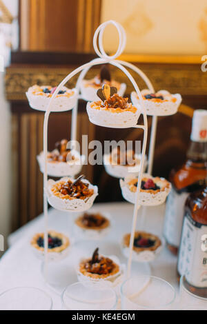 Deliziose tortine immessi sul bianco da dessert stand. Foto Stock