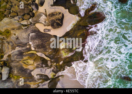 Le onde del mare di colpire le rocce di una spiaggia sulle isole Lofoten in Norvegia Foto Stock