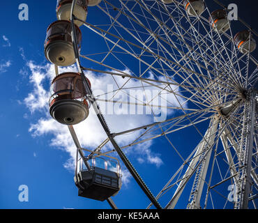 Temporary mobile ruota panoramica Ferris contro un cielo blu con una singola nuvola bianca si trova a Southampton in Inghilterra. Foto Stock