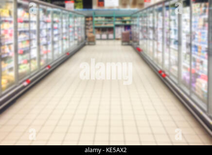 Sfocata sullo sfondo del supermercato pieno di prodotti in fila Foto Stock