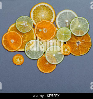 Cibi sani e il concetto di medicina. vari agrumi tagliati a fette in forma di nubi e pioggia. miscelato agrumi fettine di lime,arancio e limone Foto Stock