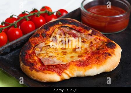 In casa la pizza con pomodori ciliegia e ketchup Foto Stock