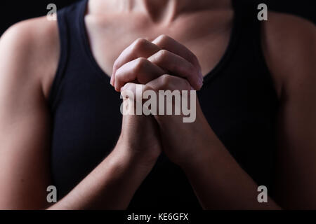 Le mani di fedeli donna orante, mani giunte, interlacciato, dita nel culto a Dio / pregare preghiera ripiegato cristiane cattoliche adoratore adorare Foto Stock