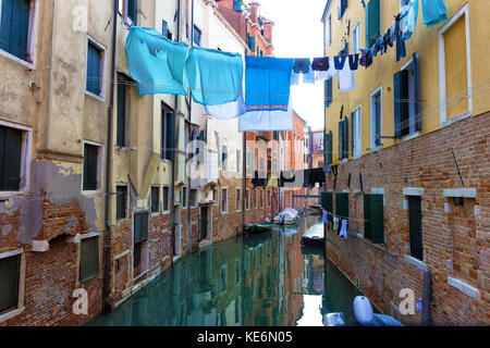 Tipica venezia canal con barche ormeggiate, gli edifici colorati e distesa panni asciutti Foto Stock