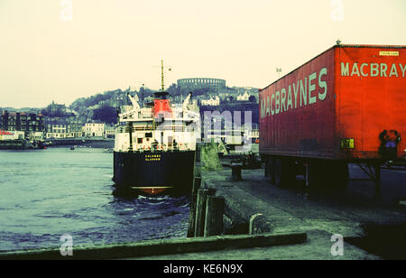 Columba, traghetto caledoniano MacBrayne ormeggiato nel porto di Oban, con la torre McCaig e il camion di trasporto MacBrayne, costa occidentale della Scozia, Regno Unito negli anni ottanta Foto Stock