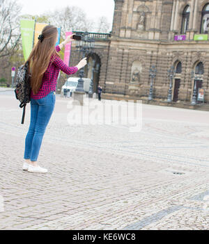 Giovane donna con capelli lunghi utilizza lo smartphone in unione città vecchia Foto Stock