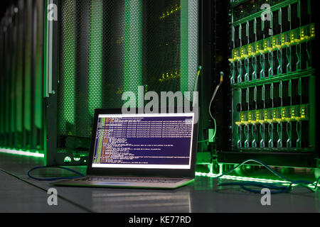 Computer portatile con lingua del computer nella sala server Foto Stock