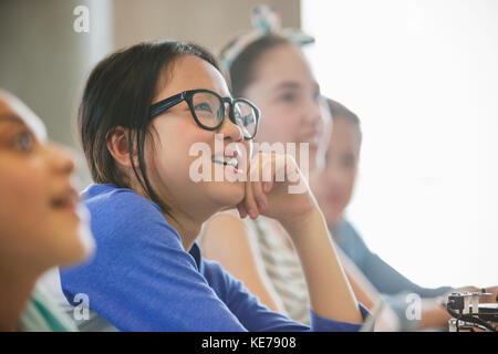 Curiosa studentessa che ascolta in classe Foto Stock