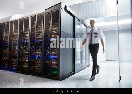 Guardia di sicurezza maschile che cammina nella sala server