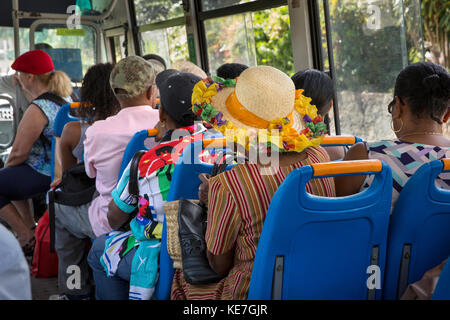La Seychelles, Mahe, Beau Vallon, il trasporto pubblico, i passeggeri sul bus locale, vecchia donna indossa decorate hat Foto Stock