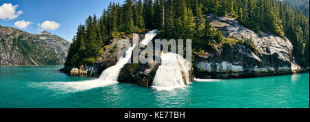 Cascate su una scogliera in acqua lungo la costa in un fiordo; Alaska, Stati Uniti d'America Foto Stock