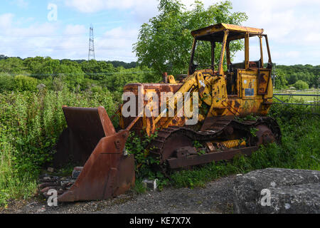 Un abbandono in disuso impianto pesante trattore macchine caterpillar scavatrice. Foto Stock