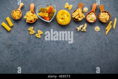 Cibi italiani del concetto e del design del menu e varie specie di farfalle, pasta un riso, orecchiette pugliesi, gnocco sardo e farfalle in cucchiai di legno Foto Stock