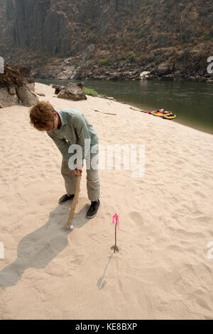 Giocare a golf sul fiume con un bastone su un fiume trip down idaho inferiore di un fiume di salmoni. Foto Stock