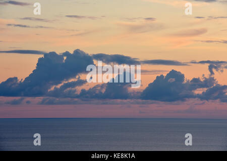 Tramonto spettacolare e orizzonte oltre il calmo mare Ionio e cirrus, altostratus, cumulus, stratocumulus e stratus nubi in rosso, arancio e giallo sky Foto Stock