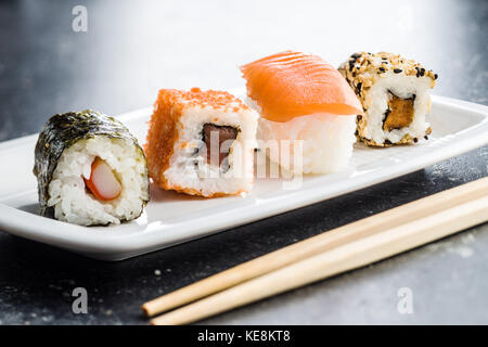 I sushi giapponesi i rotoli su un vecchio tavolo da cucina. Foto Stock