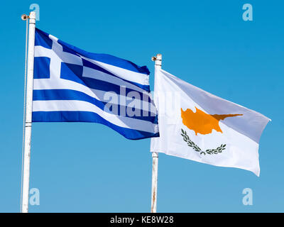 Le bandiere della Grecia e di Cipro al flutter contro un cielo blu in Paphos Cipro. Foto Stock