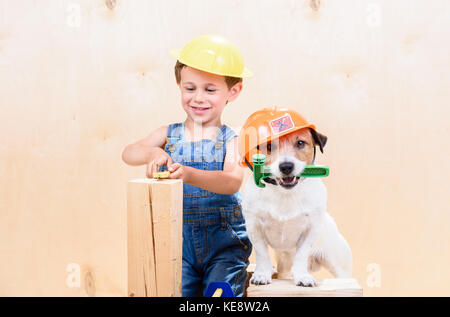 Kid e il suo animale domestico nel cantiere di lavoro come costruttori Foto Stock