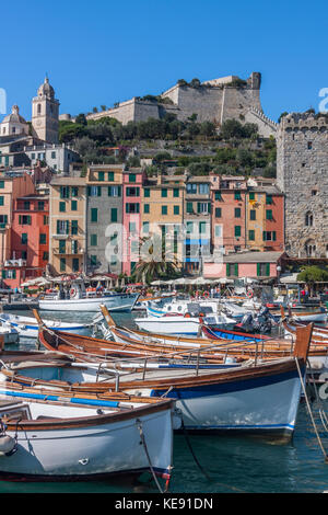 Il porto di Portovenere, sulla costa della Liguria, a nord-ovest dell'Italia. Il Castello dei Doria è sullo sfondo, dietro le righe di colorate case a schiera Foto Stock