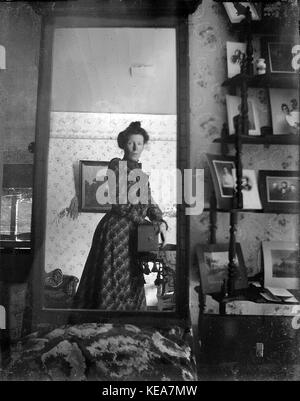 La donna non identificato tenendo la propria fotografia utilizzando uno specchio e una telecamera box, circa 1900 Foto Stock