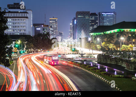 Semaforo lungo sentieri jakarta main Avenue nel quartiere degli affari di notte in Indonesia la città capitale. Il bus transjakarta ha il proprio traffico l Foto Stock