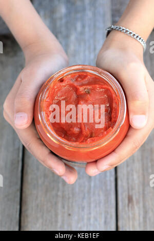 Mano azienda lasagne salsa in una giara Foto Stock