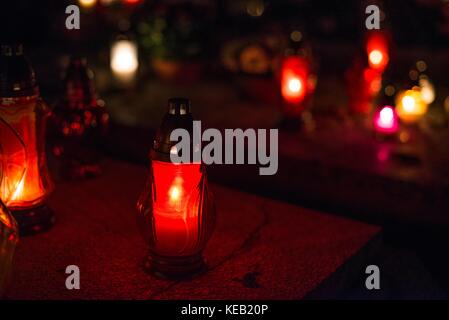Masterizzazione di candele colorate sul cimitero di notte. 1 novembre festa di tutti i santi Foto Stock
