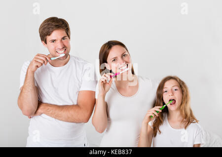 Un genitore con la loro figlia spazzolare i denti insieme Foto Stock