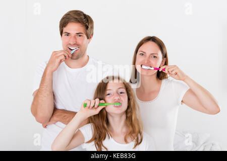 Un genitore con la loro figlia spazzolare i denti insieme Foto Stock