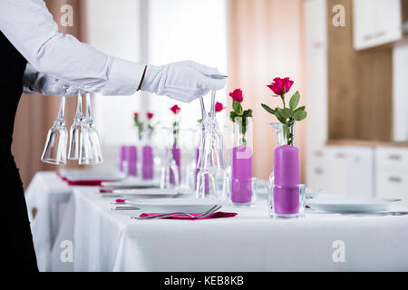 Close-up di cameriere Impostazione tabella di nozze al ristorante Foto Stock