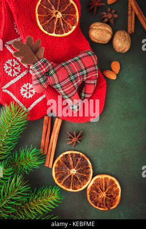 Natale e Anno Nuovo sfondo con rami di abete, i dadi e le spezie e i calzini rossi con un giocattolo deer tessuto. vista superiore Foto Stock