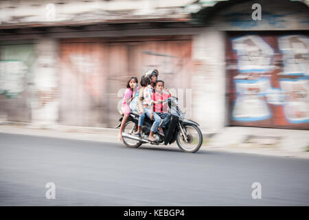 Il panning fotografia immagine di sovraccarico in moto per le strade di Indonesia, dove tre è una folla e quattro è lo stretching dei limiti della realtà! Foto Stock