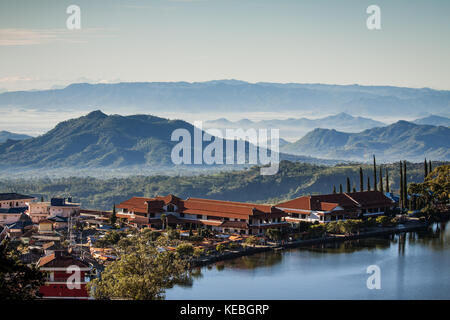 Lago sarangan (danau telaga sarangan) un bel corpo d'acqua circondato da montagne boscose e nebbie di mattina sulle pendici di un vulcano dormiente Foto Stock