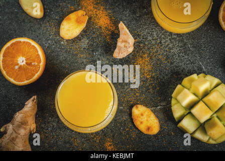 Cucina indiana ricette. cibo sano, detox acqua. tradizionale di mango indiano, arancio, curcuma e zenzero, frullato al buio su un tavolo di pietra. Copiare space t Foto Stock