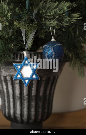 Hanukkah e decorazioni di Natale a fianco a fianco su albero di Natale Foto Stock