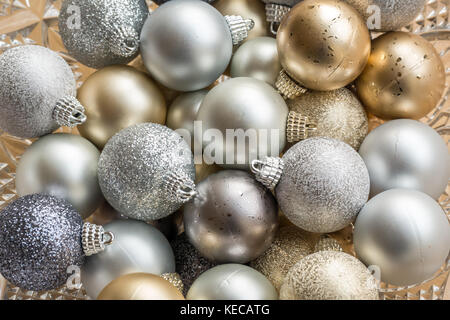 Close up di oro, argento e blu scintillante baubles di Natale in una ciotola di cristallo Foto Stock