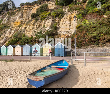 Variopinte cabine sulla spiaggia, sul lungomare di Bournemouth con una barca a remi IN PRIMO PIANO Foto Stock