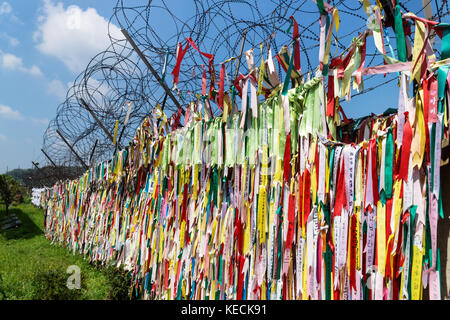 Milioni di nastri di preghiera legata alla recinzione della zona smilitarizzata DMZ presso il ponte della libertà, Corea del Sud, Asia Foto Stock